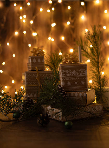 istock cozy holiday setting with wrapped gifts and pine accents illuminated by warm string lights on a rustic wooden background creating a festive and inviting atmosphere, serene, indoor, arrangement 2226961007