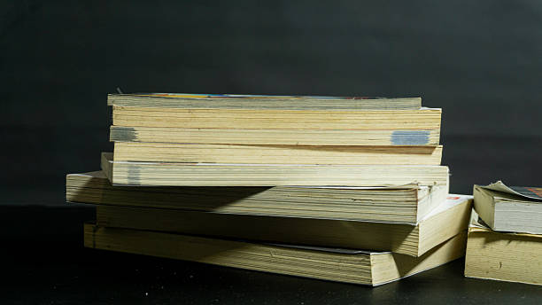 Two separate piles of books arranged on dark background, academic-themed setup suggesting study, knowledge, or library collection in clean view