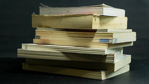 istock Messy stack of books with uneven alignment against black background, disorganized composition reflecting chaos, study, or unfinished work mood 2226963534