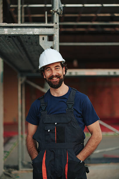 istock Smiling construction worker posing with hands in pockets near scaffolding 2226964136