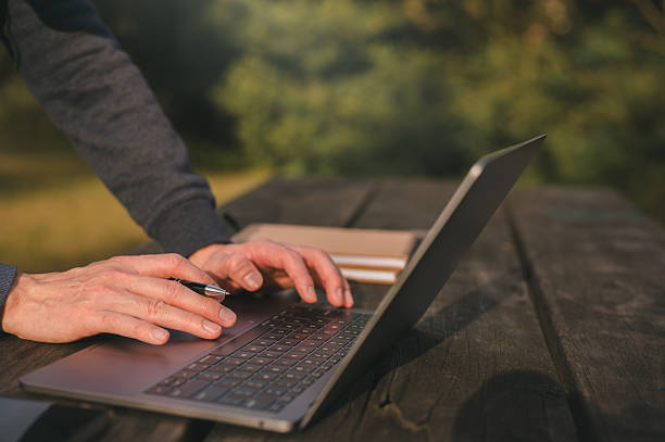 istock Freelancer Working on Laptop Outdoors in Natural Green Environment, Remote Worker use computer in Park Surrounded by Nature, Digital Nomad Typing on Laptop Outside with Lush Green Background 2226968057