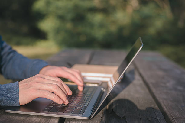 istock Freelancer Working on Laptop Outdoors in Natural Green Environment, Remote Worker use computer in Park Surrounded by Nature, Digital Nomad Typing on Laptop Outside with Lush Green Background 2226968082