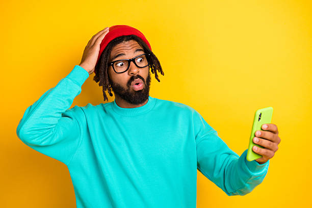 istock Portrait of brunette impressed guy hold telephone wear cap spectacles blue pullover isolated on yellow vivid color background 2226970183