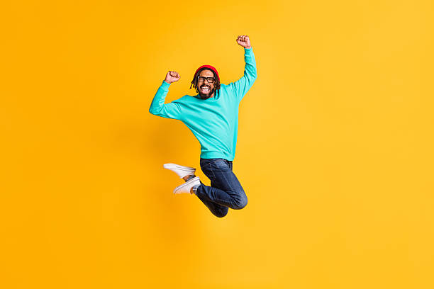istock Full size profile photo of brunette optimistic guy jump wear cap spectacles pullover jeans isolated on yellow color background 2226970342