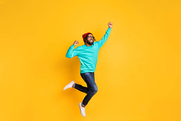 istock Full size profile photo of brunette optimistic guy jump wear cap spectacles pullover jeans sneakers isolated on yellow color background 2226973413