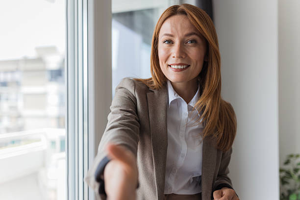 Smiling businesswoman extending hand for handshake in office
