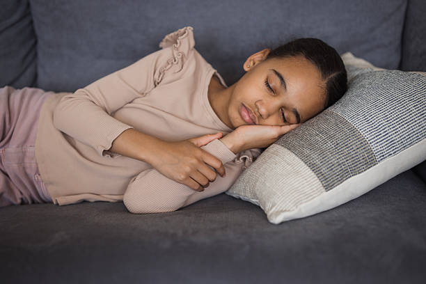 istock Young girl sleeping peacefully on comfortable sofa at home 2226985499