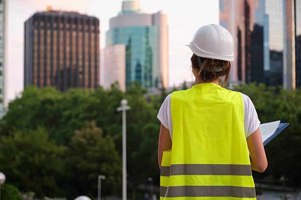 istock Female engineer wearing safety vest and helmet inspecting urban development project 2226985510