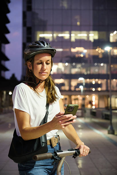 istock Woman with helmet using smartphone while riding electric scooter at night 2226986005