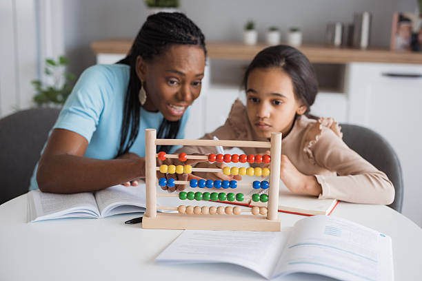 istock Mother helping daughter with homework using abacus at home 2226986333