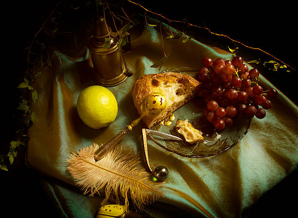 Baroque still life with red grapes, rustic bread and lemon on a green satin fabric 2, europe