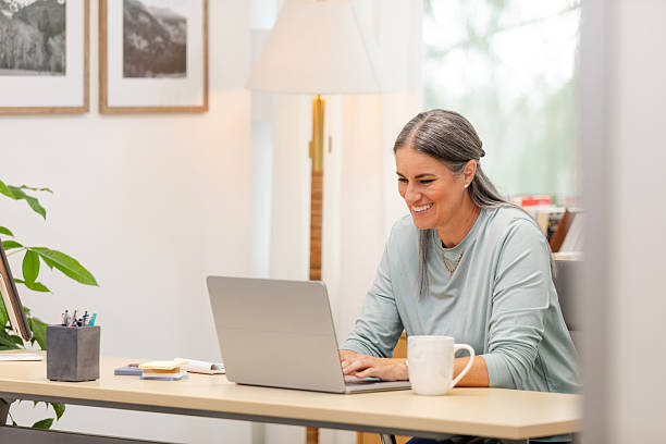 istock Smiling Woman Working on Laptop in Home Office 2226988986