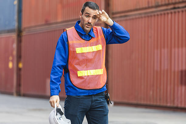 istock Tired Dock Worker Wiping Sweat Under the Hot Sun, Exhausted Engineer Taking a Break at Cargo Site in Heat, Manual Labor in Extreme Weather, Worker Struggling with Heat Stress 2226991800