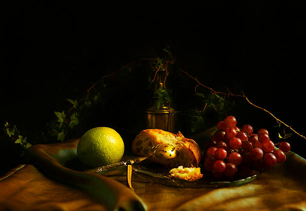 Baroque still life with red grapes, rustic bread and lemon on a green satin fabric 3, europe