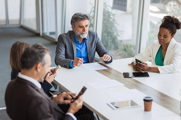 istock Business people using mobile phones during a meeting 2226995217