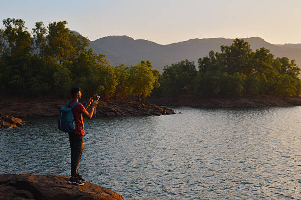 istock Man Filming Scenic Lake Sunset with Smartphone Gimbal 2226997497