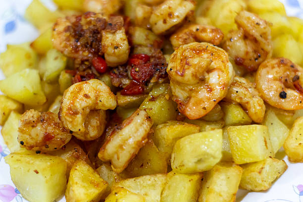 This image showcases a delicious dish featuring succulent shrimp and golden potatoes, expertly cooked and plated. The vibrant colors and textures invite the viewer to imagine the delightful flavors