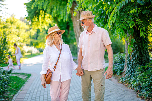 Happy senior couple holding hands while walking in a park