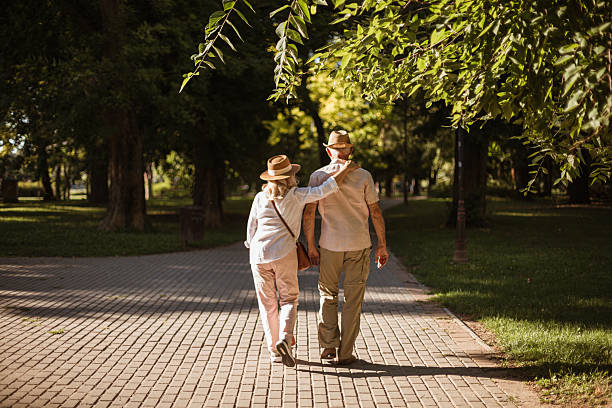 istock Elderly couple walking in park enjoying retirement 2227001175