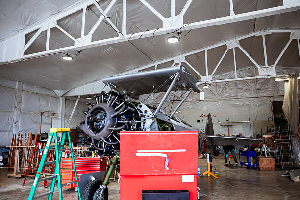 A vintage airplane is being worked on in a hanger for a restoration project. Details of the plane it's self and the project at hand.