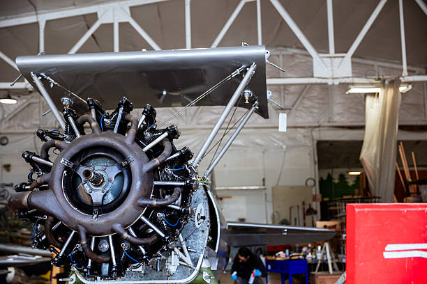 A vintage airplane is being worked on in a hanger for a restoration project. Details of the plane it's self and the project at hand.