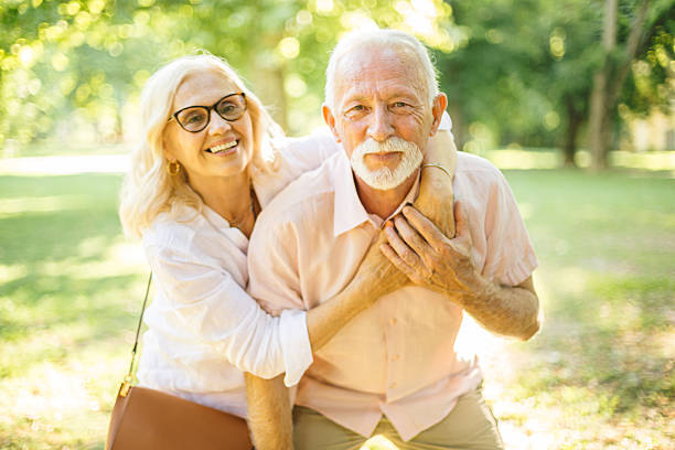 istock Happy senior couple embracing in a sunny park 2227001978