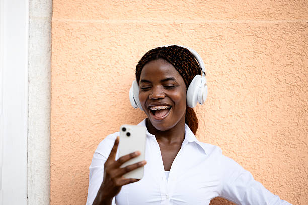 istock Happy smiling African woman using smart phone and laughing. 2227005720