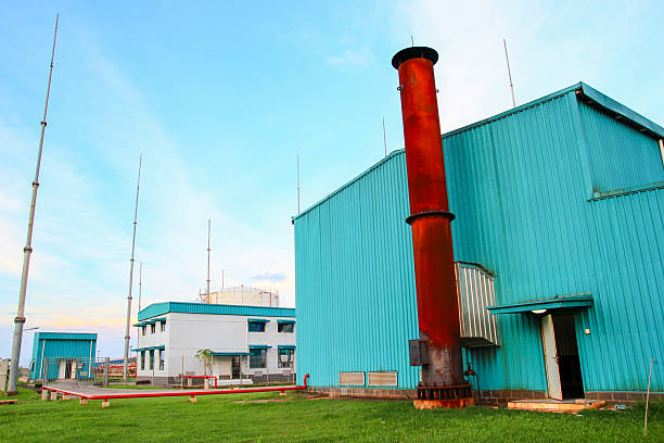 istock Exterior view of a modern industrial building complex with a chimney stack and antennas 2227006500