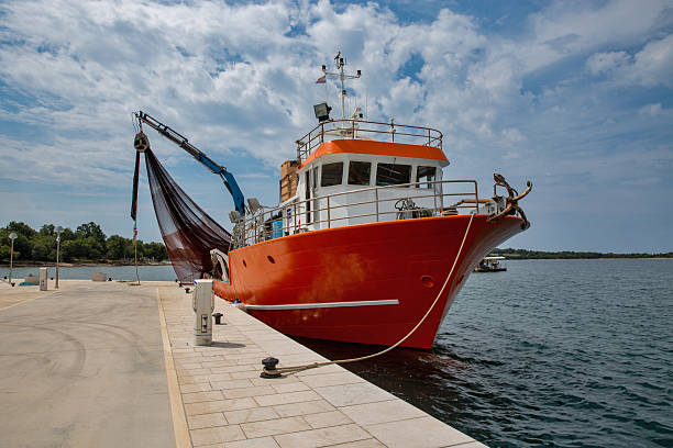 Fishing boat at a landing stage on the promenade of the fishing village of Fazana in Croatia