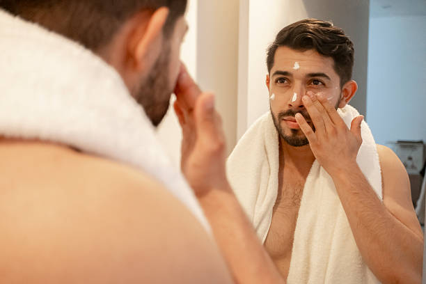 istock young bearded man using facial cream all over his face after showering 2227008314