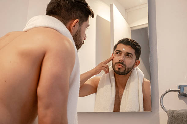 istock young bearded man using facial cream all over his face after showering 2227008344