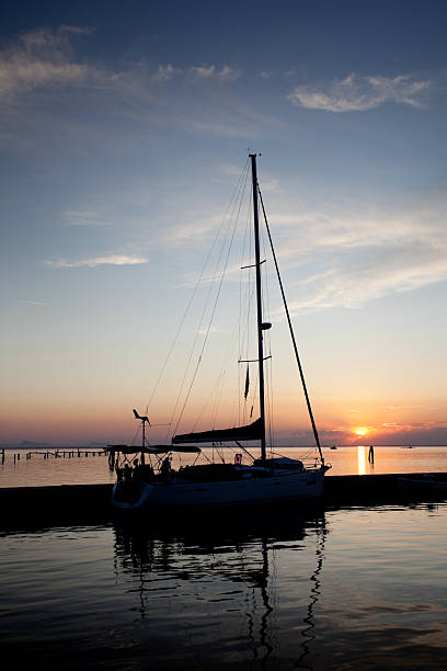 Pellestrina - Venice, Italy -June 27, 2025. Old sailing boat in the dock, Venetian Lagoon at sunset.