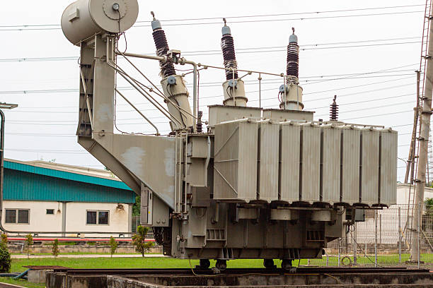 istock Large industrial high voltage transformer distributing electrical power outside building 2227009822