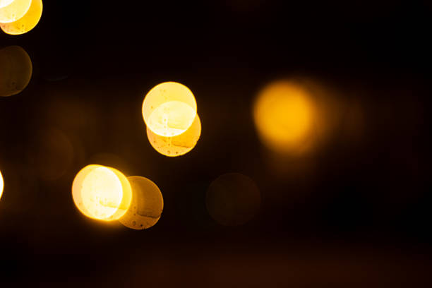 istock Abstract blurred bokeh light background with warm yellow tones and dark setting creates a soothing 2227009986