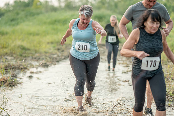 istock Group of Runners Participating in Muddy Outdoor Obstacle Course Competition 2227010329