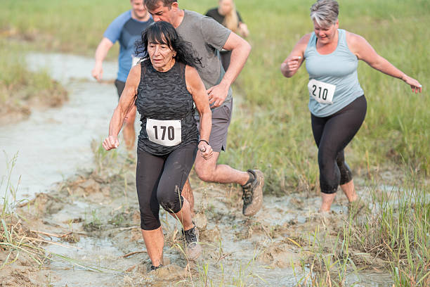 istock Group Participating in a Mud Run Event in Nature 2227010354