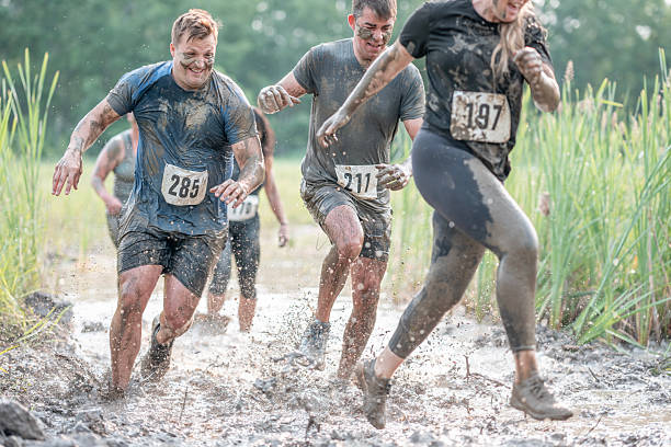 istock Participants Running Through Mud in an Outdoor Obstacle Race Event 2227010889