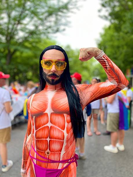 Madrid, Spain - July 5, 2025: Participant wearing a muscle suit flexing muscles during the annual Madrid Gay Pride (MADO) parade on Paseo del Prado street in Madrid, Spain.\n\n*This image is part of the entire photojournalism coverage of MADO Madrid Gay Pride. You can see other images such as: MADO Madrid LGBTIQ+ Parade; the election of Mr. Gay Spain at Plaza de España; massive Concerts around the city; and other events in my Picture and Video Portfolio.