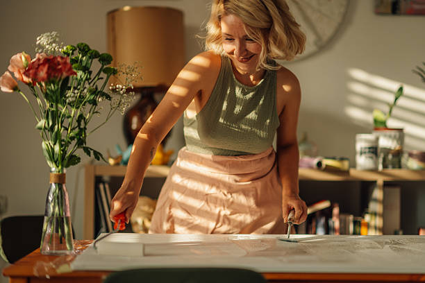 Artist printing linocut at home using baren tool
