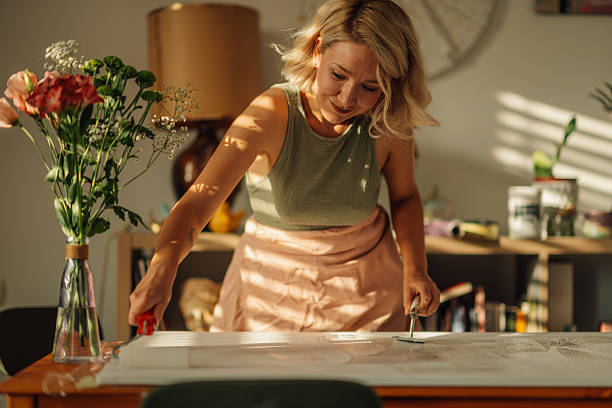 istock Female artist priming canvas in art studio at home 2227019729