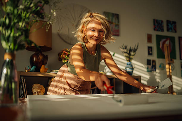 istock Female artist priming canvas in sunny art studio 2227019764