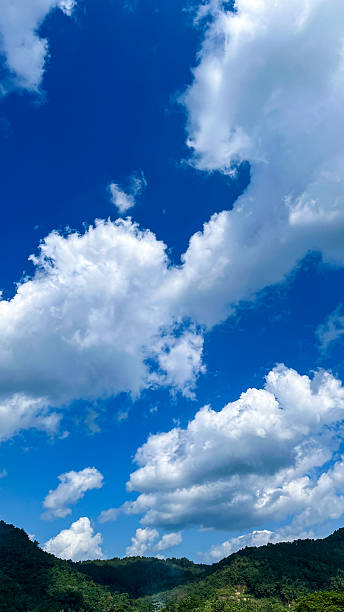 istock green hills under blue sky with fluffy clouds 2227020282