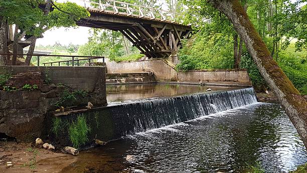 istock On small river there is an artificial waterfall under wooden bridge in the forest 2227021635