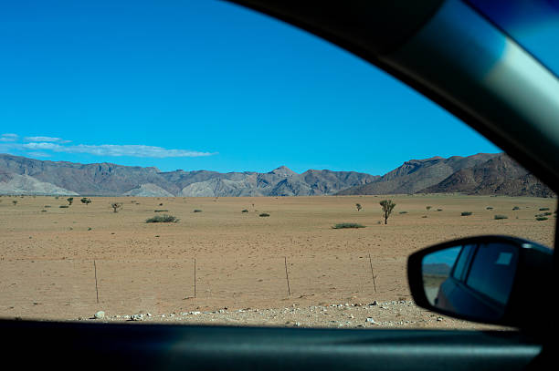Namibian landscape with desert, trees and mountains. View from a car. Namibia