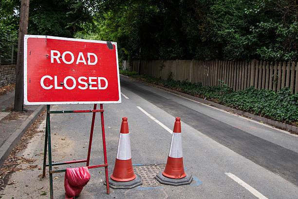 istock Red Road Closed sign positioned by the roadside. 2227022311