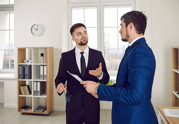 istock Real estate agent, mortgage broker, or business advisor talking with client about contract 2227030048