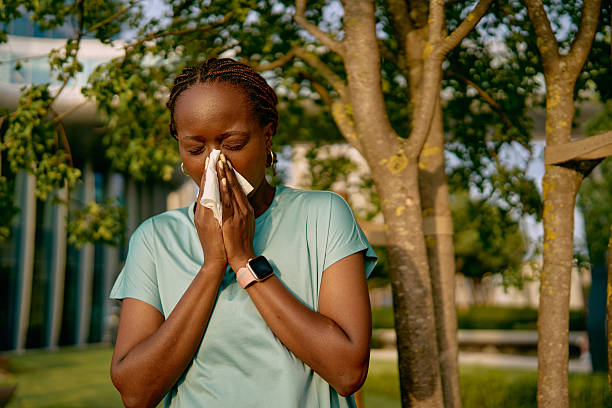 istock Young woman blowing her nose while exercising outdoors 2227030469