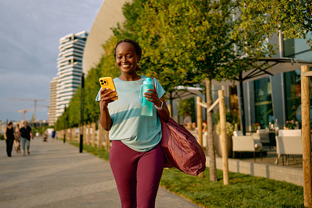istock Young woman walking after exercising and using her smartphone 2227030476