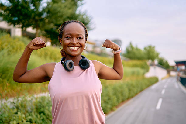 istock Young woman flexing biceps after exercising outdoors 2227030576