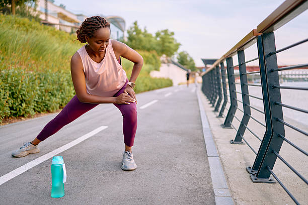 istock Young woman stretching her legs before running near a river 2227030614